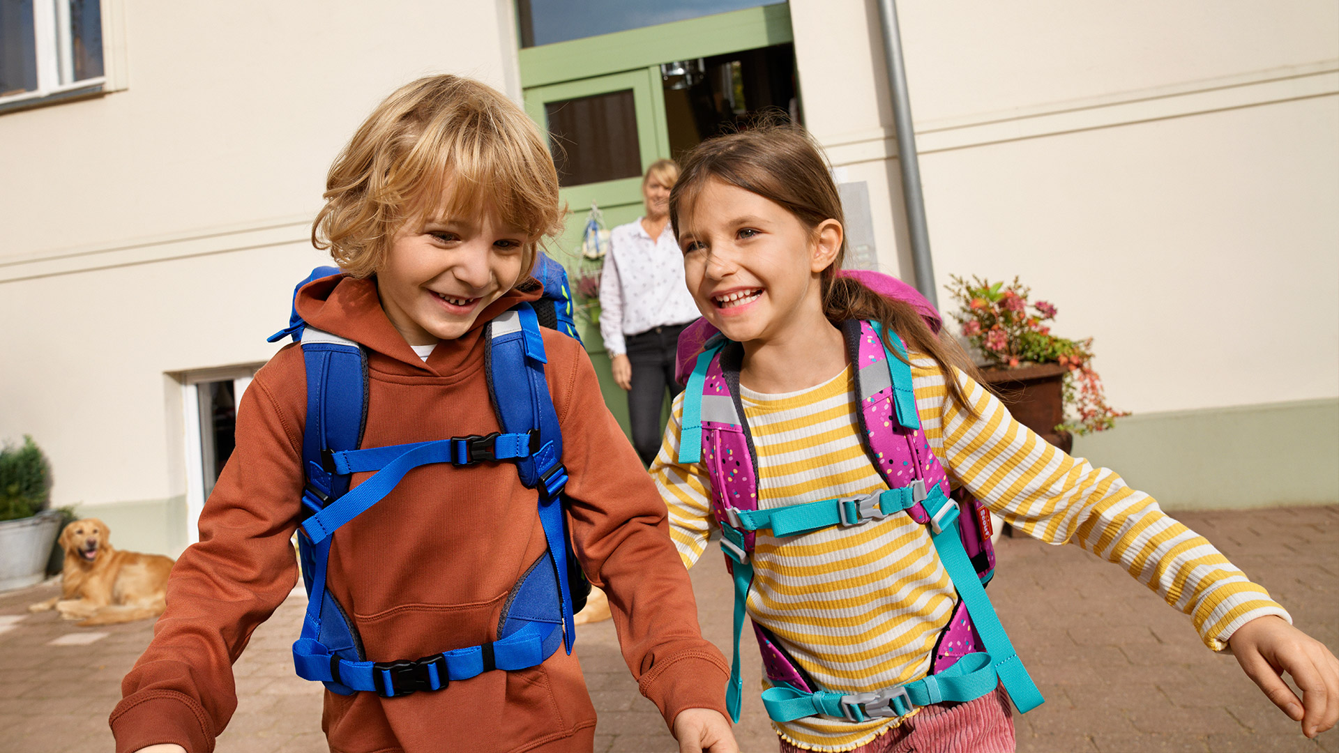 Bruder und Schwester rennen glücklich aus der Schule