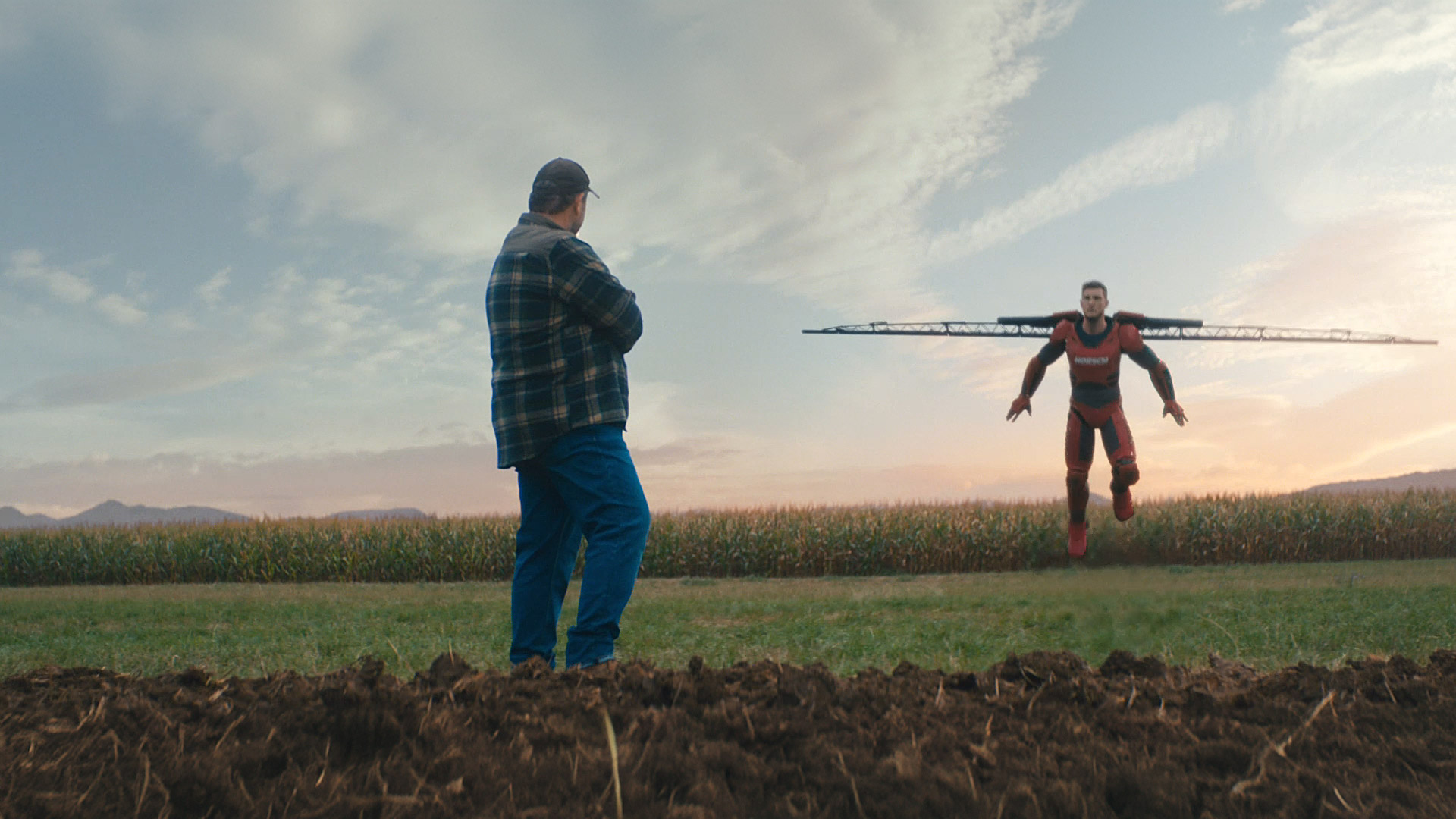 Der Farming Hero landet in seinem Superanzug auf dem Feld. Sein stolzer Vater steht daneben und ist schwer beeindruckt.